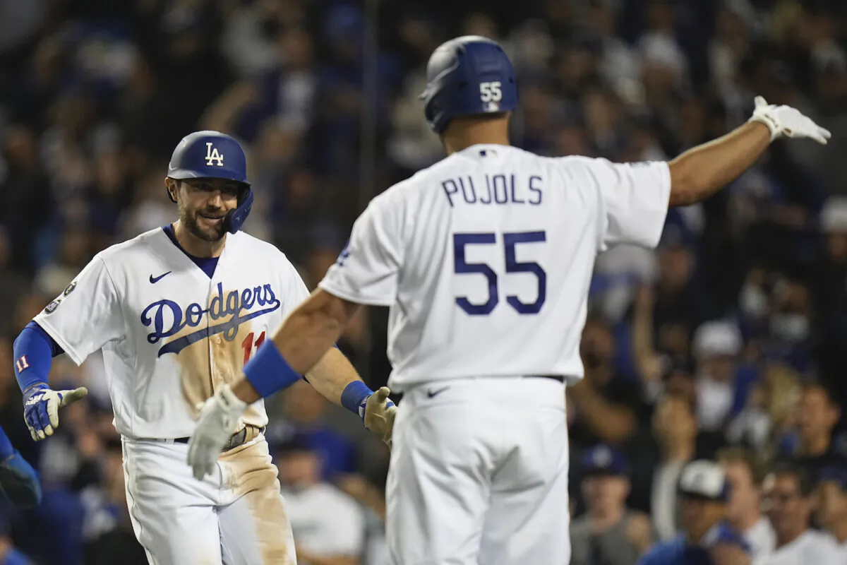 Los Angeles Dodgers' AJ Pollock is congratulated by Albert Pujols after hitting a three-run home run during the eighth inning against the Atlanta Braves in Game 5 of baseball’s National League Championship Series in Los Angeles on Oct. 21, 2021. (AP Photo/Jae C. Hong)
