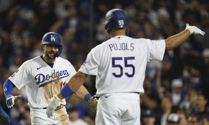 Los Angeles Dodgers' AJ Pollock is congratulated by Albert Pujols after hitting a three-run home run during the eighth inning against the Atlanta Braves in Game 5 of baseball’s National League Championship Series in Los Angeles on Oct. 21, 2021.  (AP Photo/Jae C. Hong)
