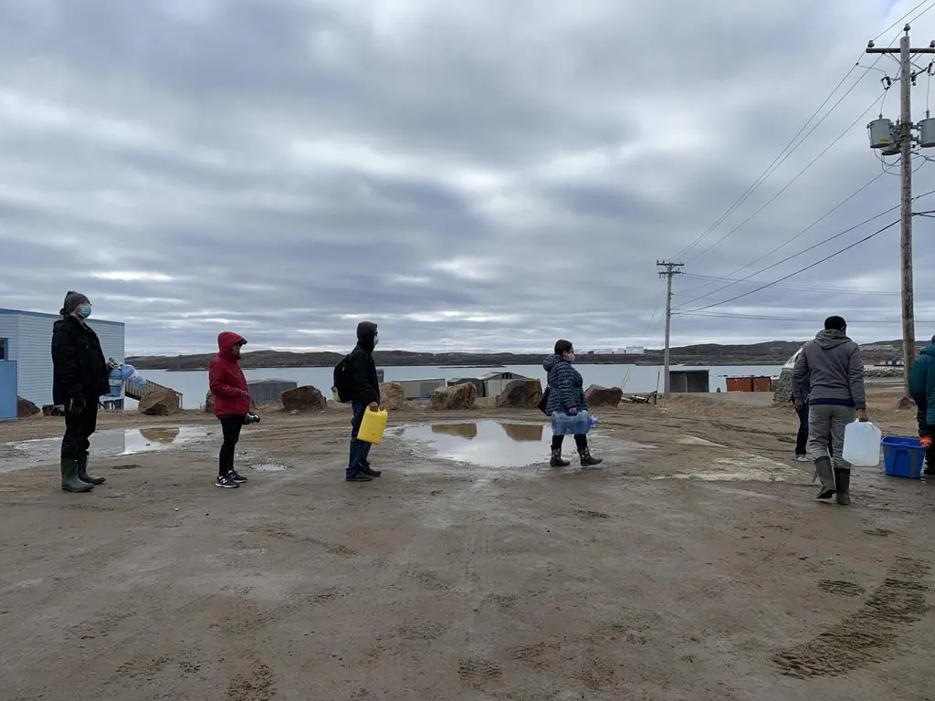 Residents line up to fill containers with potable water in Iqaluit on Oct. 14, 2021. (The Canadian Press/Emma Tranter)