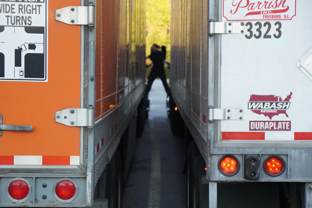 A female trucker stands between rigs while talking at the One9 truck stop in Wildwood, Ga., on Oct. 18, 2021. (Jackson Elliott/The Epoch Times)