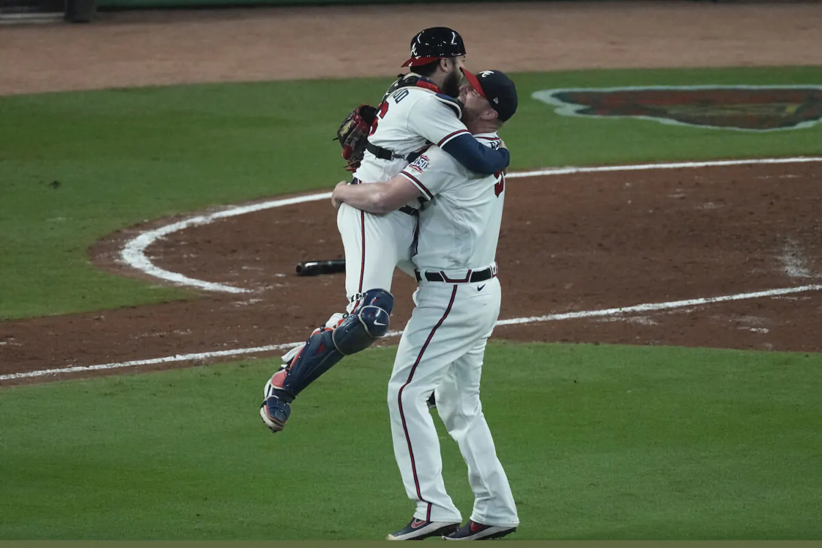 Atlanta Braves catcher Travis d'Arnaud hugs pitcher Will Smith after winning Game 6 of baseball’s National League Championship Series against the Los Angeles Dodgers in Atlanta on Oct. 23, 2021. (AP Photo/John Bazemore)