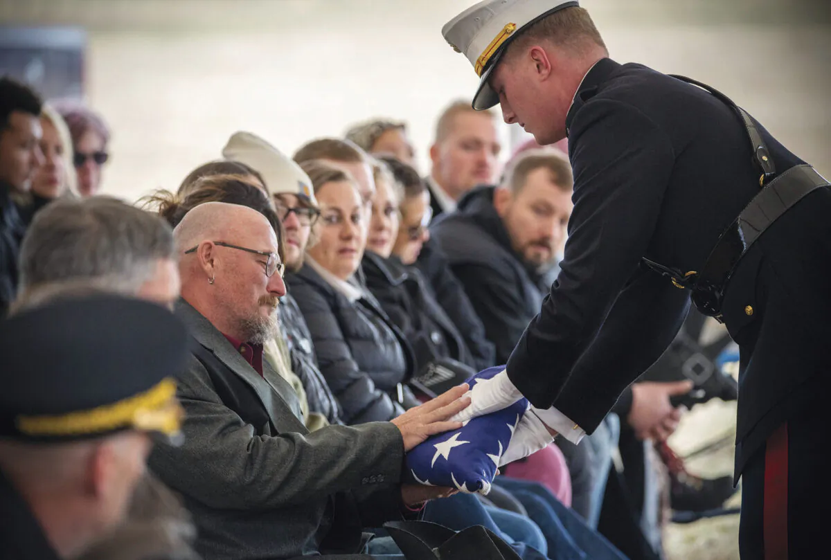 A U.S. Marine with the Golf Company, 1st Marines presents Jim McCollum with a folded American flag during memorial services for his son, Lance Cpl. Rylee McCollum at the Gill Ranch in Jackson, Wyo., on Oct. 23, 2021. (Bradly J. Boner/Jackson Hole News & Guide via AP)