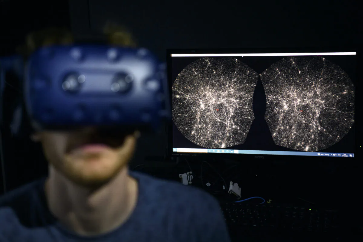 A software engineer at EPFL's Laboratory for Experimental Museology (eM+) explores with a virtual reality helmet the most detailed 3D map of the universe with the virtual reality software VIRUP, Virtual Reality Universe Project developed by Swiss Federal Institute of Technology, in St-Sulpice near Lausanne, Switzerland, on Oct. 12, 2021. (Laurent Gillieron/Keystone via AP)