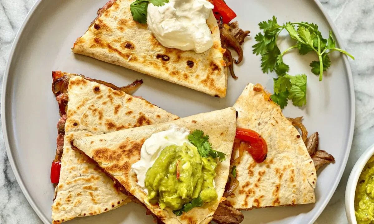 Inspired by fajitas, these quesadillas are packed with thin slices of cumin-rubbed flank steak, charred peppers and onions, and plenty of melty cheese. (Kelli Foster/TNS)