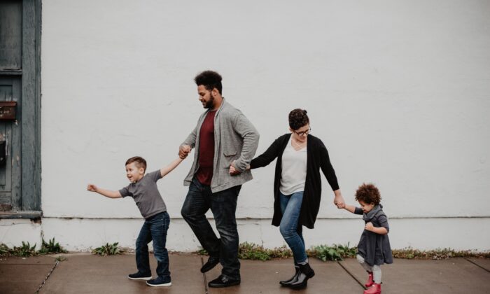 A family of four is walking on the street. (Emma Bauso/Pexels)
