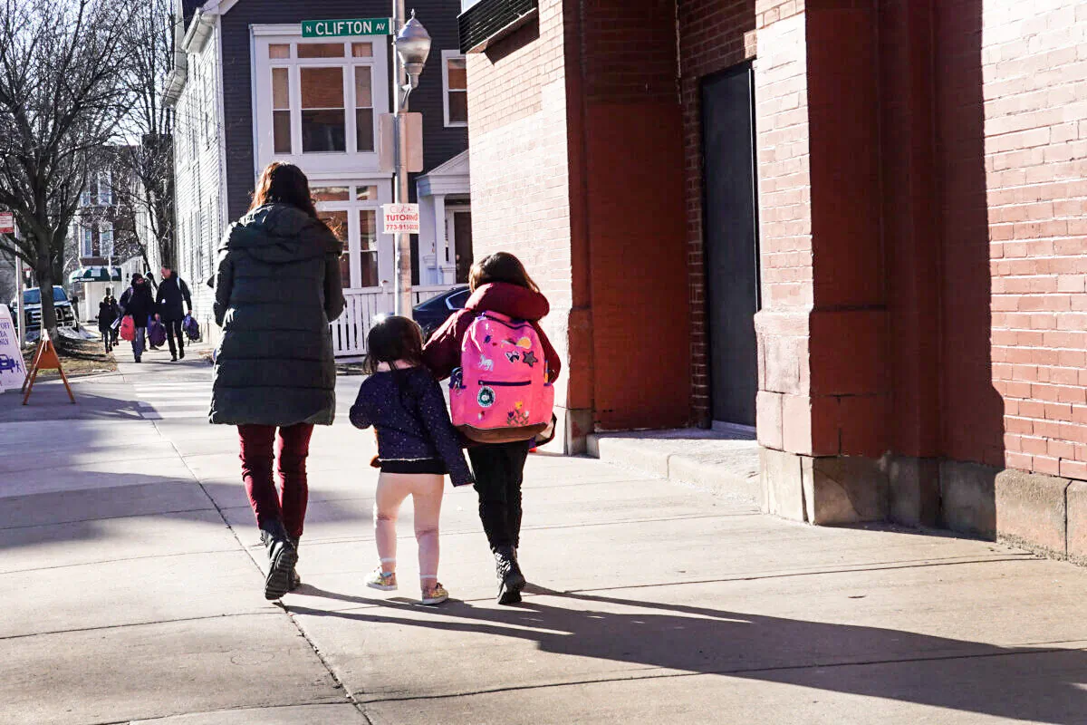 A mom picks up her children at school in Chicago on March 1, 2021. (Scott Olson/Getty Images)