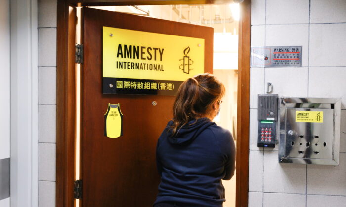 A woman enters the Amnesty International Hong Kong office, after its announcement to close citing China-imposed national security law, in Hong Kong, on Oct. 25, 2021. (Reuters/Tyrone Siu)