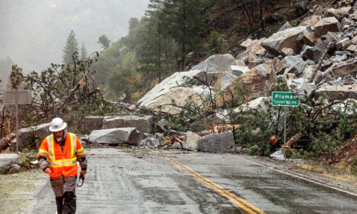 Caltrans maintenance supervisor Matt Martin walks by a landslide covering Highway 70 in the Dixie Fire zone in Plumas County, Calif., on Oct. 24, 2021. (AP Photo/Noah Berger)


