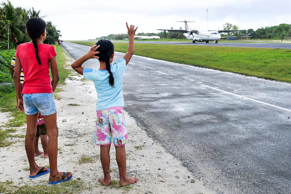 People gather at the airport three times a week to welcome and farewell passengers from Suva of Fiji in Funafuti, Tuvalu, on Aug. 15, 2018. (Fiona Goodall/Getty Images for Lumix)