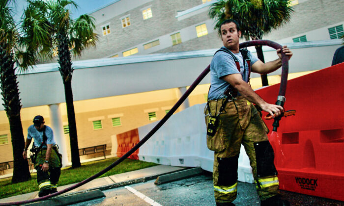 Orange County firemen use a hose to fill protective barriers with water in front of the booking and release center at the Orange County Jail July 15, 2011 in Orlando, Florida. (Joe Raedle/Getty Images)