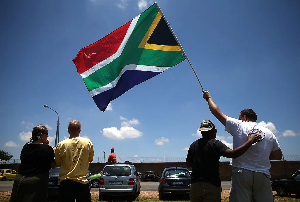 People wait alongside the road to see a military plane take off from Waterkloof military airbase that is carrying the casket of former South African President Nelson Mandela in Pretoria, South Africa, on Dec. 14, 2013. (Justin Sullivan/Getty Images)