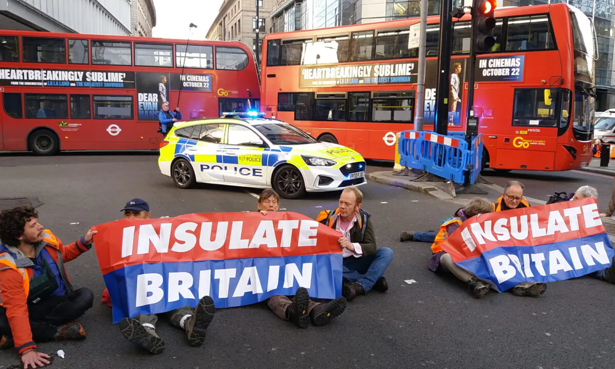 Handout photo issued by Insulate Britain of protesters blocking a road in Liverpool Street, central London, on Oct. 25, 2021. (Insulate Britain via PA)