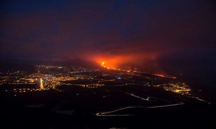 The Cumbre Vieja volcano, pictured from Tijarafe, spews lava, ash, and smoke, connected  the Canary Island of La Palma, Spain, astatine  nighttime  connected  Oct. 10, 2021. (Jorge Guerrero/AFP via Getty Images)