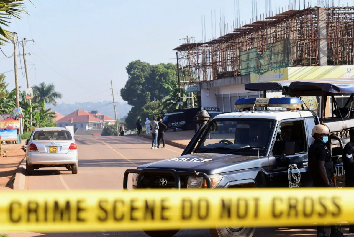 Ugandan police members secure the scene of an explosion in Komamboga, Kampala, Uganda, on Oct. 24, 2021. (Abubaker Lubows/Reuters)