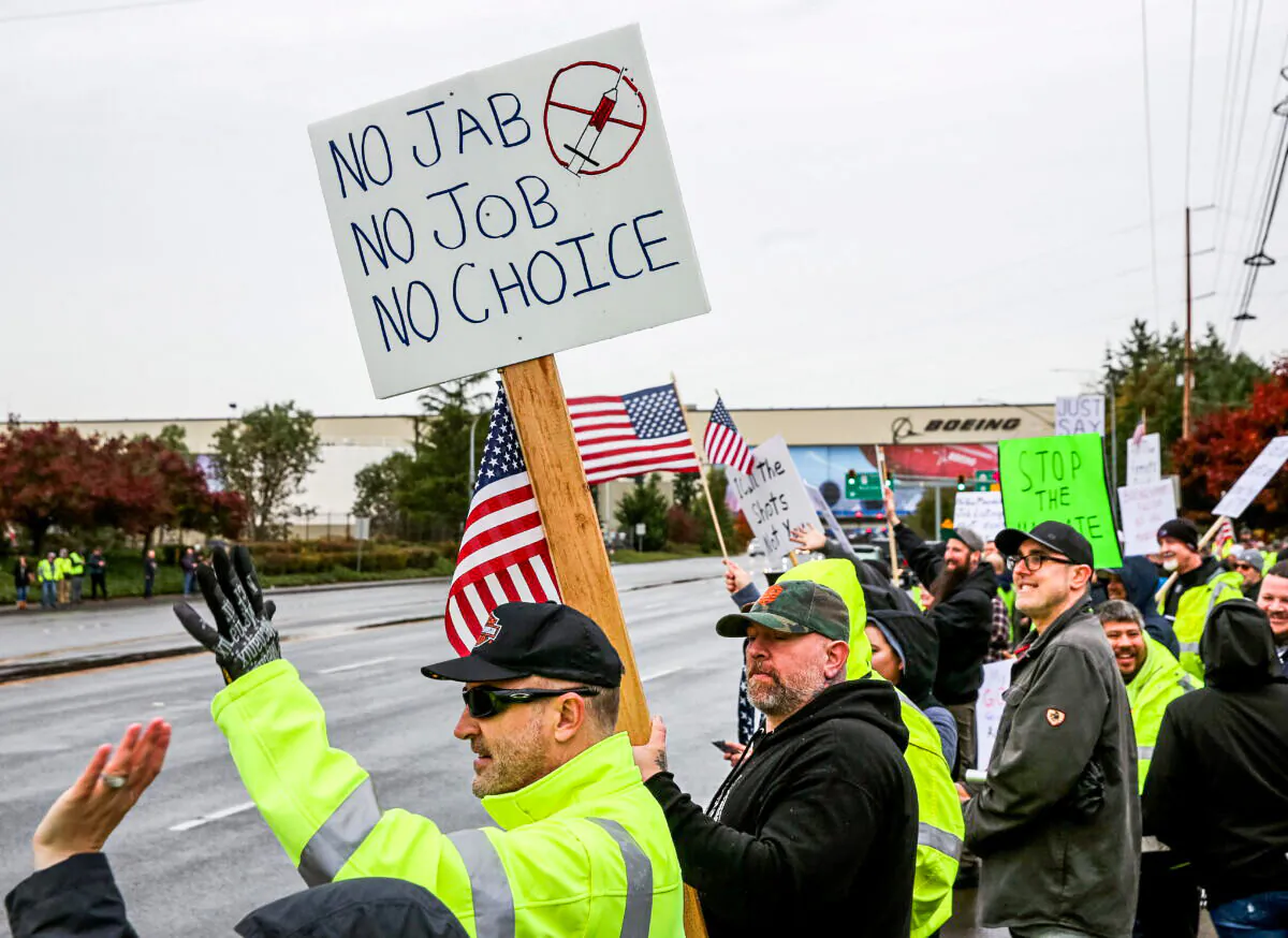 Boeing employees and others line the street with signs and American flags as they protest the company's COVID-19 vaccine mandate, outside the Boeing facility in Everett, Washington, on Oct. 15, 2021. (Lindsey Wasson/Reuters)
