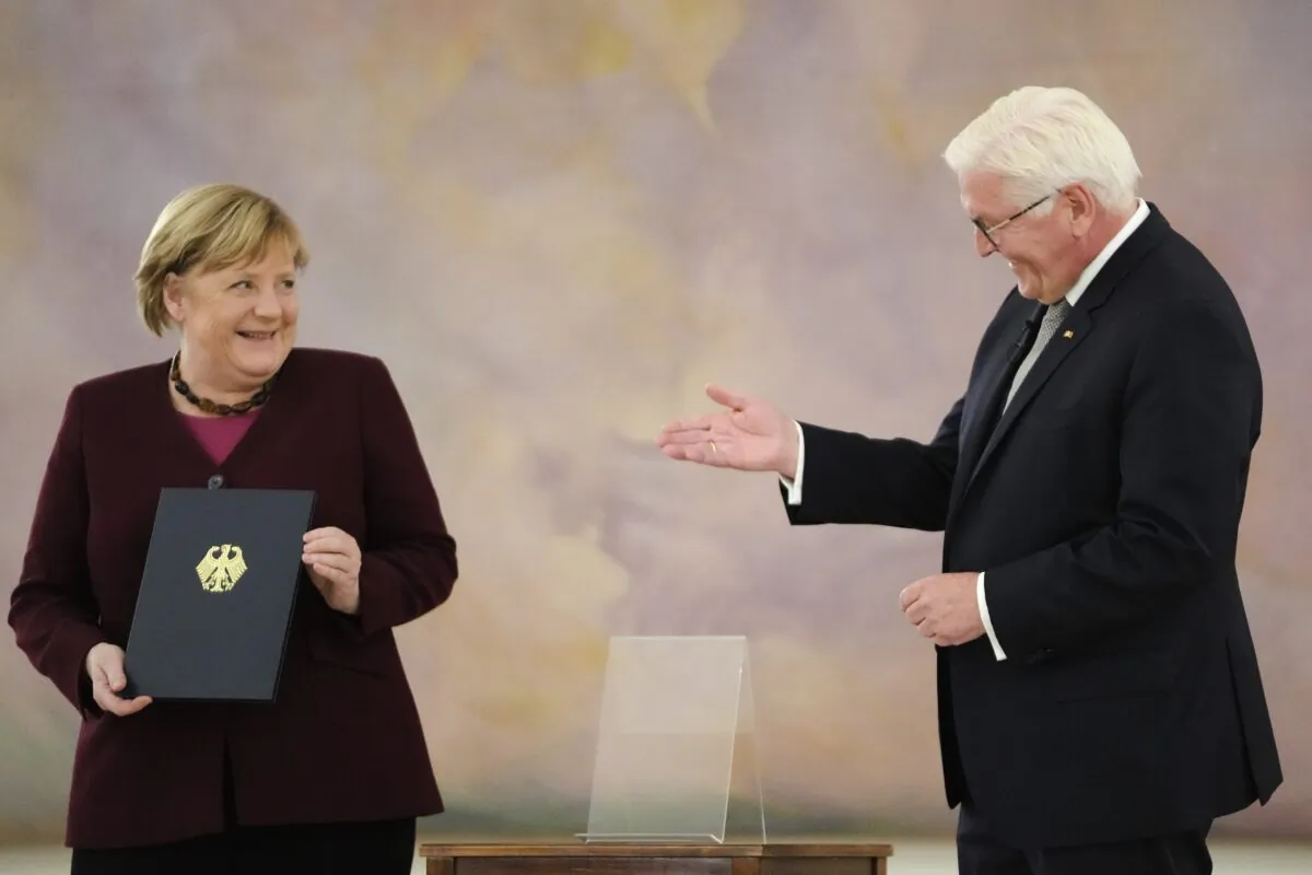 German Chancellor Angela Merkel (L) receives her certificate of dismissal from German President Frank-Walter Steinmeier in Berlin, Germany, on Oct. 26, 2021. (Markus Schreiber/AP Photo)