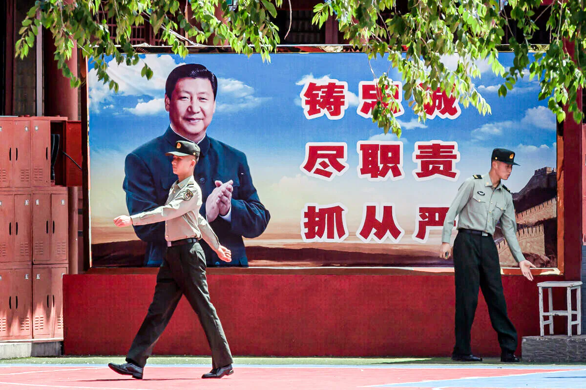 Soldiers are seen near a poster of Chinese leader Xi Jinping next to the entrance to the Forbidden City in Beijing on May 18, 2020. (Nicolas Asfouri/AFP via Getty Images)