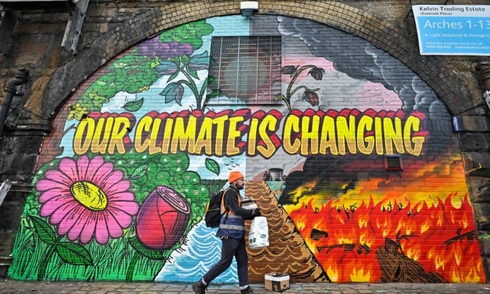 Artists paint a mural on a a wall next to the Clydeside Expressway near Scottish Events Centre (SEC) which will be hosting the COP26 UN Climate Summit in Glasgow, Scotland, on Oct. 13, 2021. (Jeff J Mitchell/Getty Images)