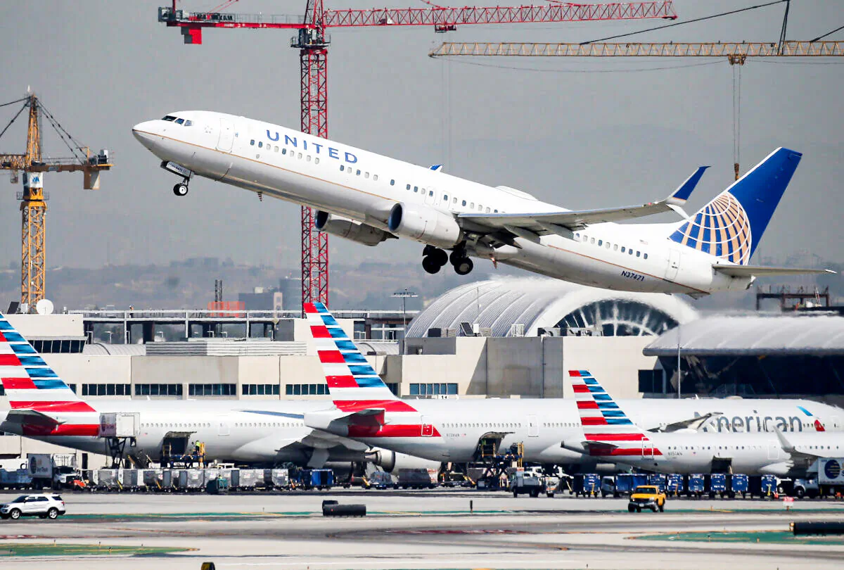 A United Airlines plane takes off above American Airlines planes on the tarmac at Los Angeles International Airport (LAX) in Los Angeles, Calif., on Oct. 1, 2020. (Mario Tama/Getty Images)
