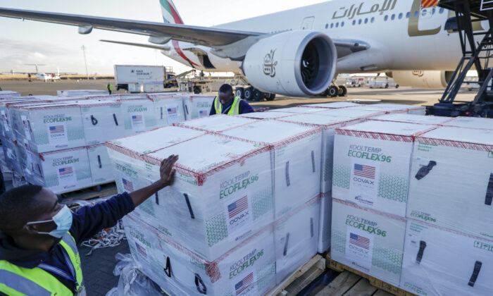 An airdrome  idiosyncratic    stands adjacent  to boxes of Moderna coronavirus vaccine, donated by the U.S. authorities  via the COVAX facility, aft  their accomplishment  astatine  the airdrome  successful  Nairobi, Kenya, connected  Aug. 23, 2021. (Brian Inganga/AP Photo)