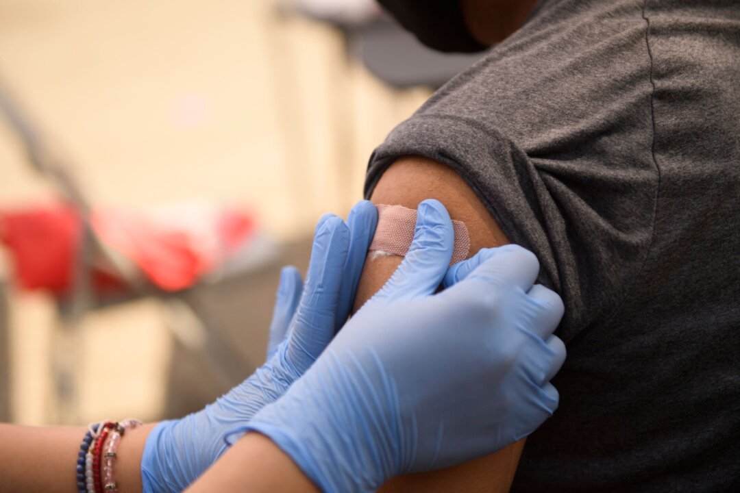A person receives a bandage after their first dose of the Pfizer COVID-19 vaccine at a clinic in Los Angeles, Calif., on Aug. 7, 2021. (Patrick T. Fallon/AFP via Getty Images)