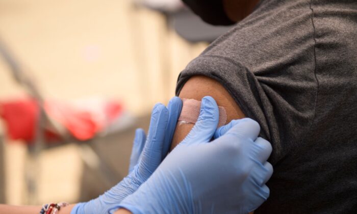 A person receives a bandage after their first dose of the Pfizer COVID-19 vaccine at a clinic in Los Angeles, Calif., on Aug. 7, 2021. (Patrick T. Fallon/AFP via Getty Images)