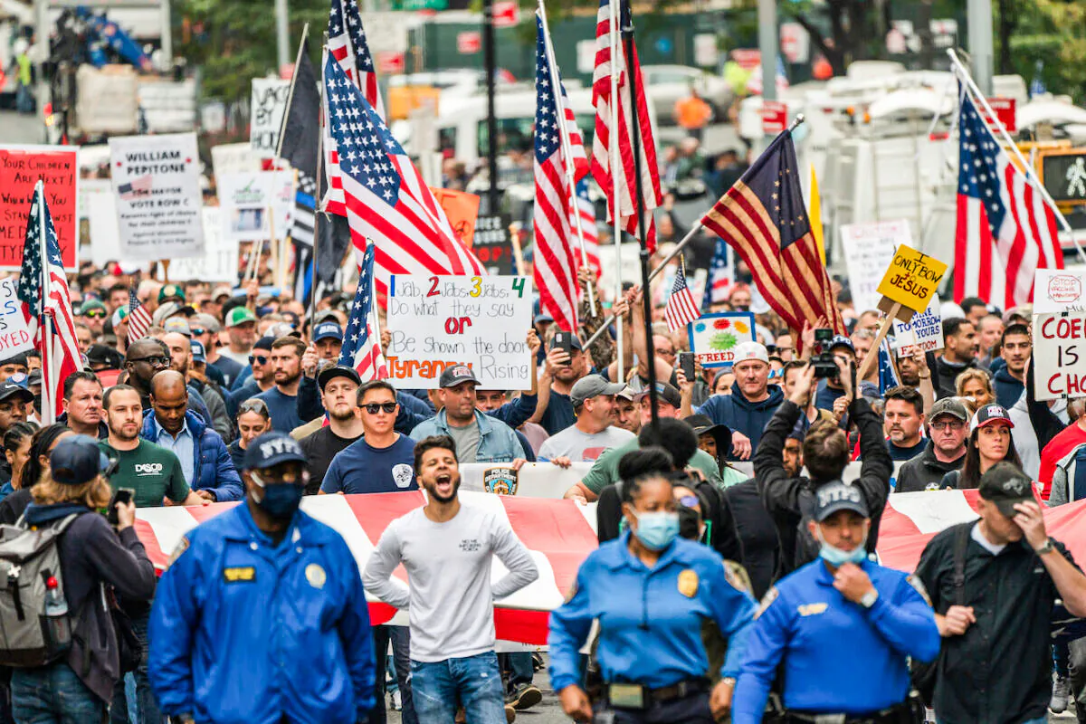 People march across the Brooklyn Bridge to protest the COVID-19 vaccine mandate for municipal workers in New York City on Oct. 25, 2021. (David Dee Delgado/Getty Images)