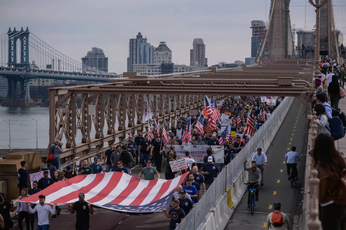 Municipal workers march across Brooklyn Bridge during a protest against the COVID-19 vaccine mandate, in New York, on Oct. 25, 2021. (Ed Jones/AFP via Getty Images)