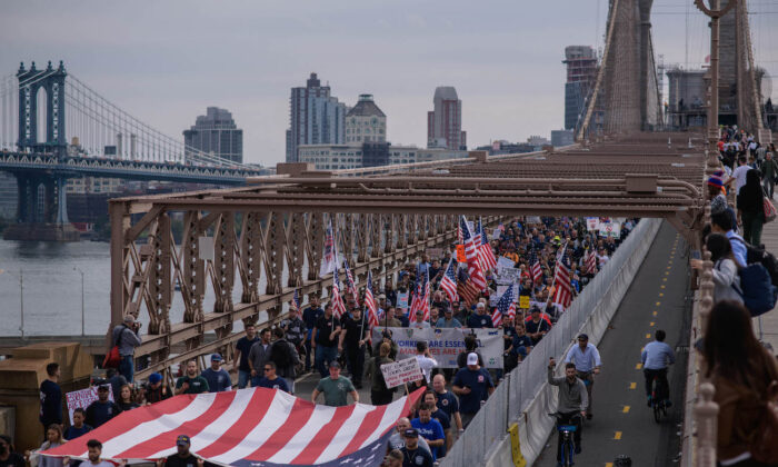 Municipal workers march across Brooklyn Bridge during a protest against the COVID-19 vaccine mandate, in New York, on Oct. 25, 2021. (Ed Jones/AFP via Getty Images)