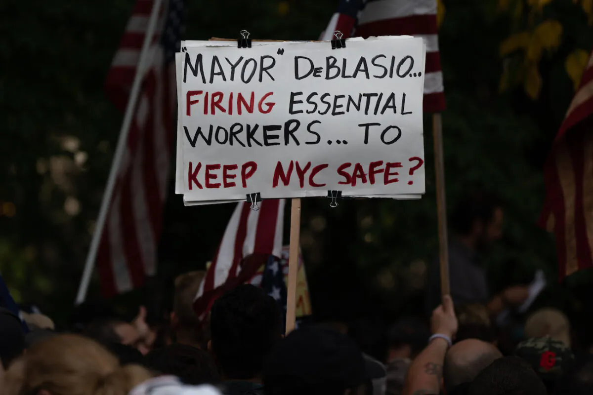 People march across the Brooklyn Bridge to protest the Covid-19 vaccine mandate for municipal workers in New York City, on Oct. 25, 2021. (David Dee Delgado/Getty Images)