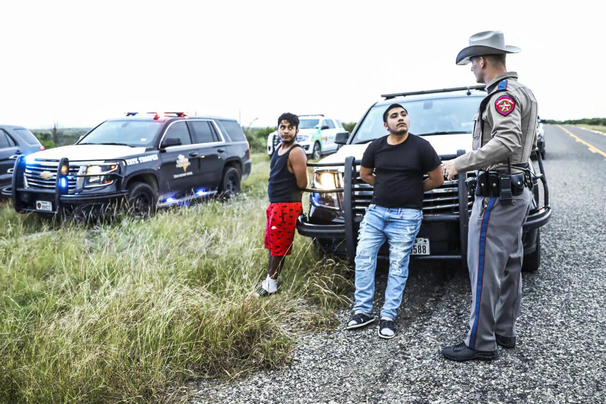 Texas State Troopers arrest two U.S. citizens who were transporting three illegal aliens to San Antonio, in Kinney County, Texas, on Oct. 20, 2021. (Charlotte Cuthbertson/The Epoch Times)