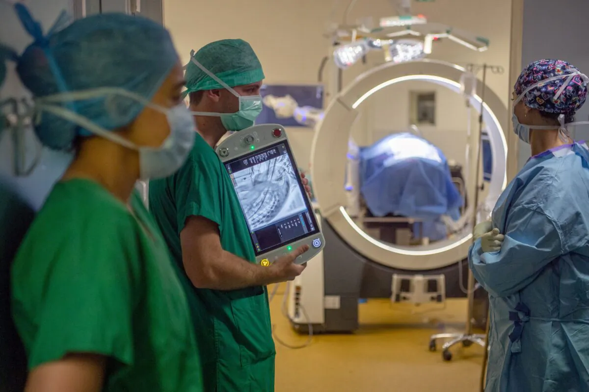 A surgeon team uses a Loop-X live medical imagery system to secure the work on the spine of a patient affected by a metastatic breast cancer at the University-affiliated hospital (CHU) in Angers, western France on June 10, 2021. (AFP via Getty Images/Loic Venance)