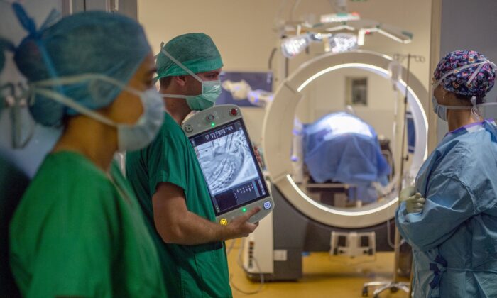 A surgeon team uses a Loop-X live medical imagery system to secure the work on the spine of a patient affected by a metastatic breast cancer at the University-affiliated hospital (CHU) in Angers, western France on June 10, 2021. (AFP via Getty Images/Loic Venance)