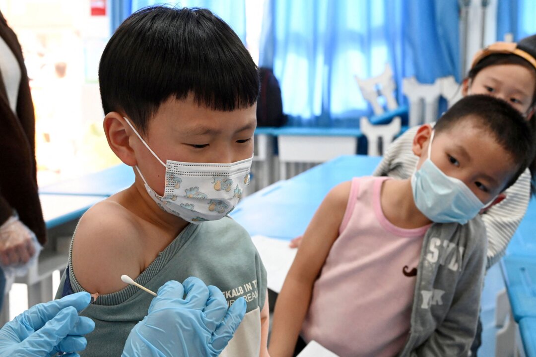 A child receives the Covid-19 coronavirus vaccine at a school in Handan, in China's northern Hebi province on October 27, 2021, after the city began vaccinating children between the ages of 3 to 11. (AFP via Getty Images)