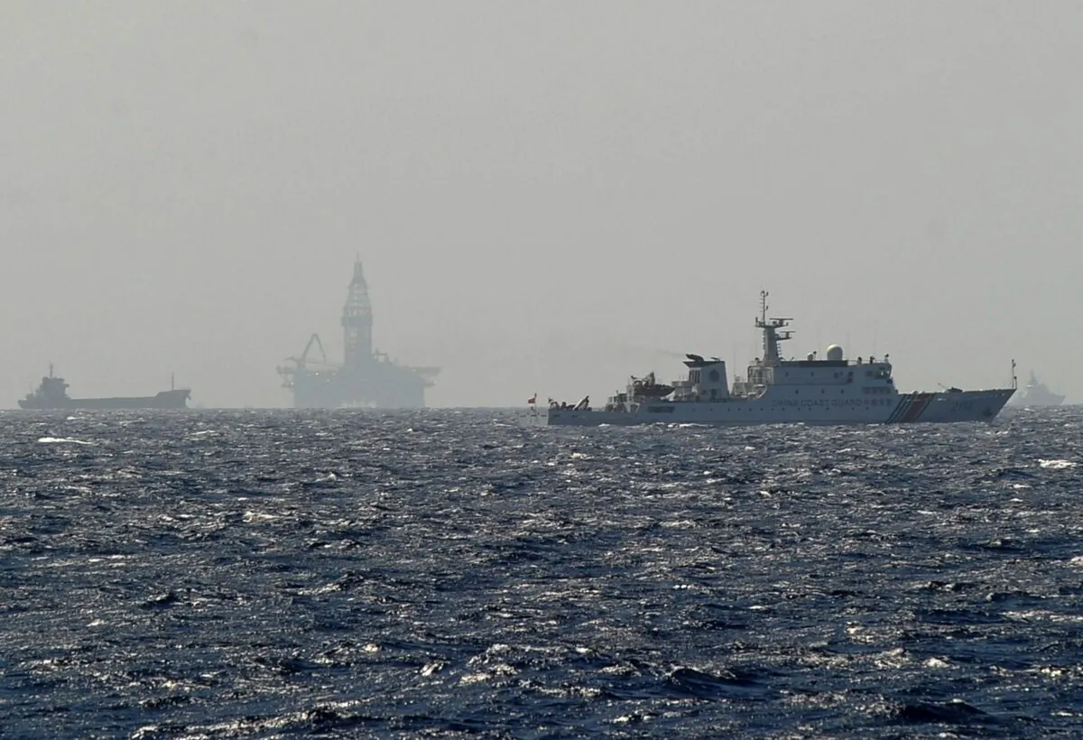 A Vietnamese coast guard ship shows a Chinese coast guard vessel (R) sailing near China's oil drilling rig in disputed waters in the South China Sea on May 14, 2014. (Hoang Dinh Nam/AFP via Getty Images)