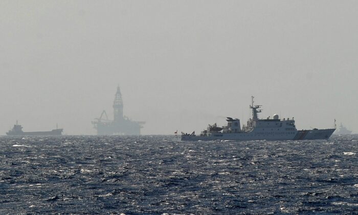 A Vietnamese coast guard ship shows a Chinese coast guard vessel (R) sailing near China's oil drilling rig in disputed waters in the South China Sea on May 14, 2014. (Hoang Dinh Nam/AFP via Getty Images)
