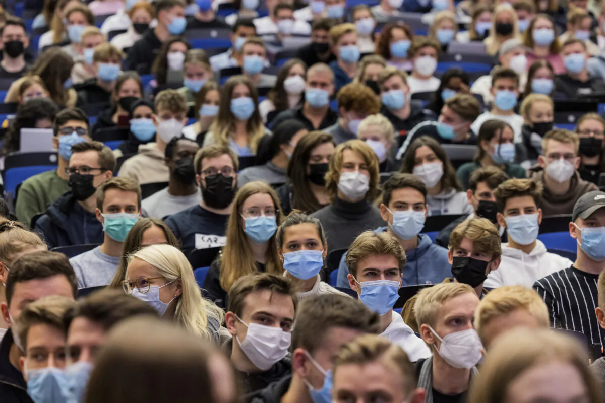 Students wear mouth-to-nose coverings while sitting close to each other during the lecture 'BWL 1' in lecture hall H1 of the Westfaelische Wilhelms-Universitaet in Muenster, Germany, on Oct. 11, 2021. (Rolf Vennenbernd/dpa via AP)