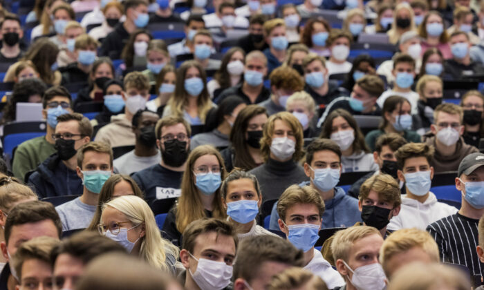 Students wear mouth-to-nose coverings while sitting close to each other during the lecture 'BWL 1' in lecture hall H1 of the Westfaelische Wilhelms-Universitaet in Muenster, Germany, on Oct. 11, 2021. (Rolf Vennenbernd/dpa via AP)
