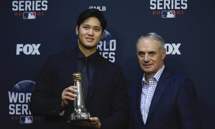 Shohei Ohtani holds the Commissioner’s Historic Achievement Award from Rob Manfred before Game 1 in baseball’s World Series between the Houston Astros and the Atlanta Braves in Houston on Oct. 26, 2021. (AP Photo/Ashley Landis)
