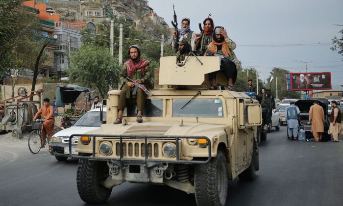 Taliban fighters atop a Humvee vehicle take part in a rally in Kabul, on Aug. 31, 2021. (Hoshang Hashimi/AFP via Getty Images)