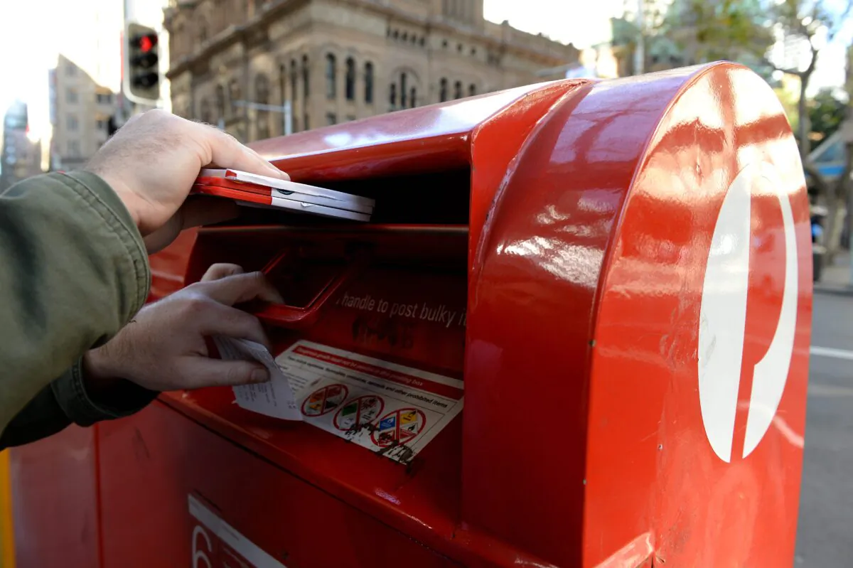 A man posting mail at an Australia Post postbox in Sydney, Australia, Sept. 2, 2013. (AAP Image/Dan Himbrechts)