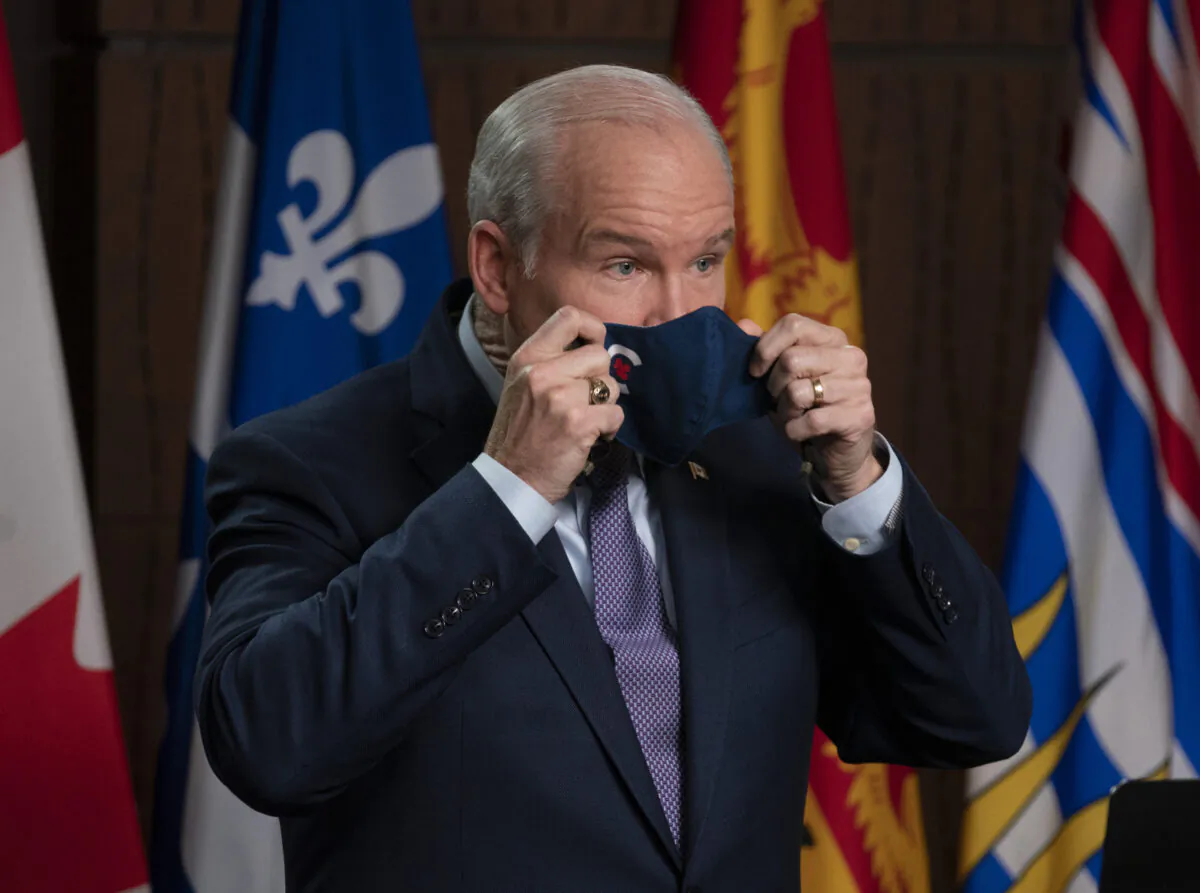Conservative Leader Erin O'Toole puts on his mask as he steps up to the podium at a news conference on Parliament Hill, Oct. 27, 2021 in Ottawa. (The Canadian Press/Adrian Wyld)