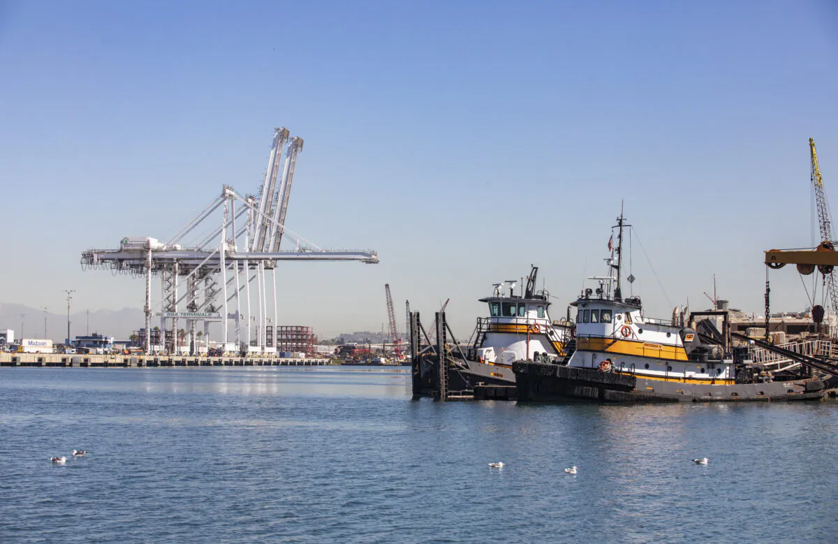 Cargo cranes and tug boats are idle at the Port of Long Beach, Calif., on Oct. 27, 2021. (John Fredricks/The Epoch Times)
