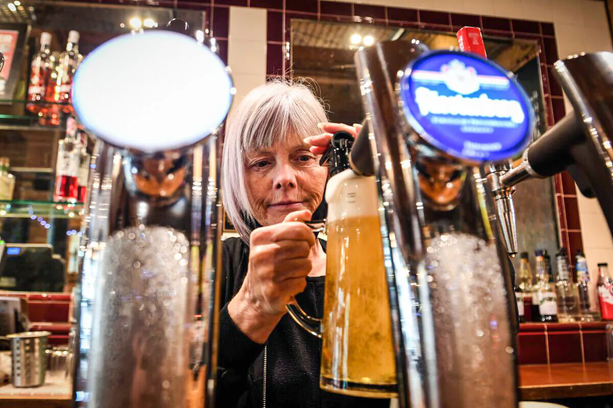 An employee pours a draught beer in Jackson's Bar in the city centre of Glasgow on October 8, 2020. (Andy Buchanan / AFP)