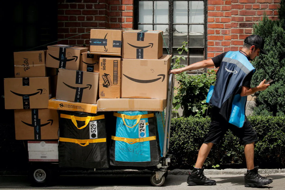An Amazon delivery worker pulls a delivery cart full of packages during its annual Prime Day promotion in New York City, on June 21, 2021. (Brendan McDermid/Reuters)