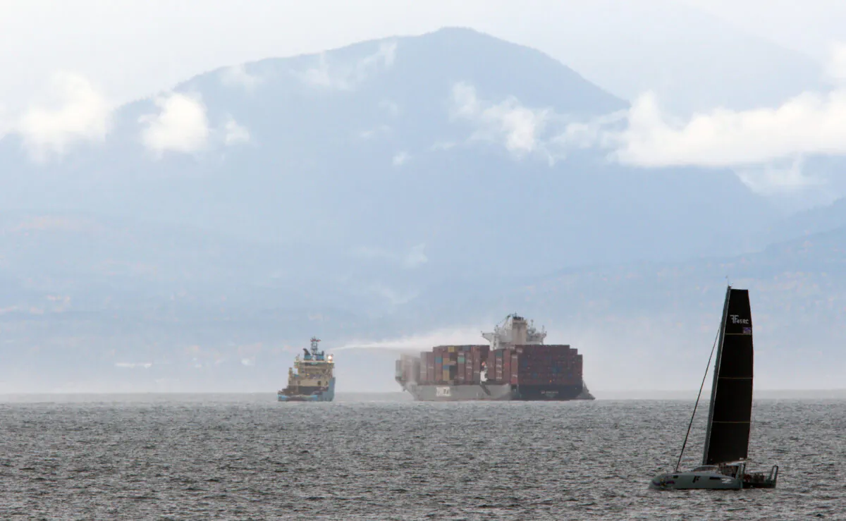 Ships work to control a fire onboard the MV Zim Kingston about eight kilometres from the shore in Victoria, B.C., on Oct. 24, 2021. (The Canadian Press/Chad Hipolito)