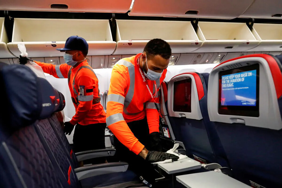 Delta Air Lines pre-flight cleaning crew members work on an aircraft at JFK International Airport, N.Y., on Aug. 6, 2020. (Shannon Stapleton/Reuters)