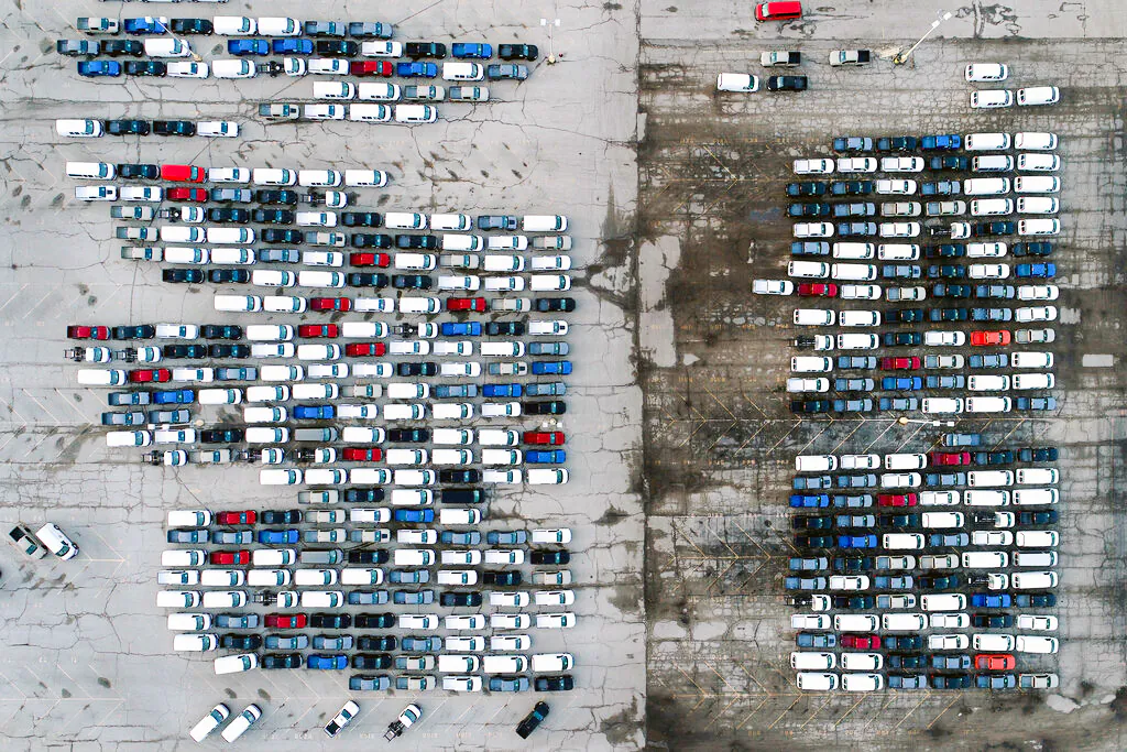 Mid-sized pickup trucks and full-size vans are seen in a parking lot outside a General Motors assembly plant where they are produced in Wentzville, Mo, on March 24, 2021. (Jeff Roberson/AP Photo)