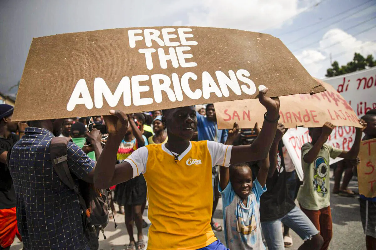 People protest for the release of kidnapped missionaries near the Ohio-based Christian Aid Ministries headquarters in Titanyen, north of Port-au-Prince, Haiti, on Oct. 19, 2021. (Joseph Odelyn/AP Photo)