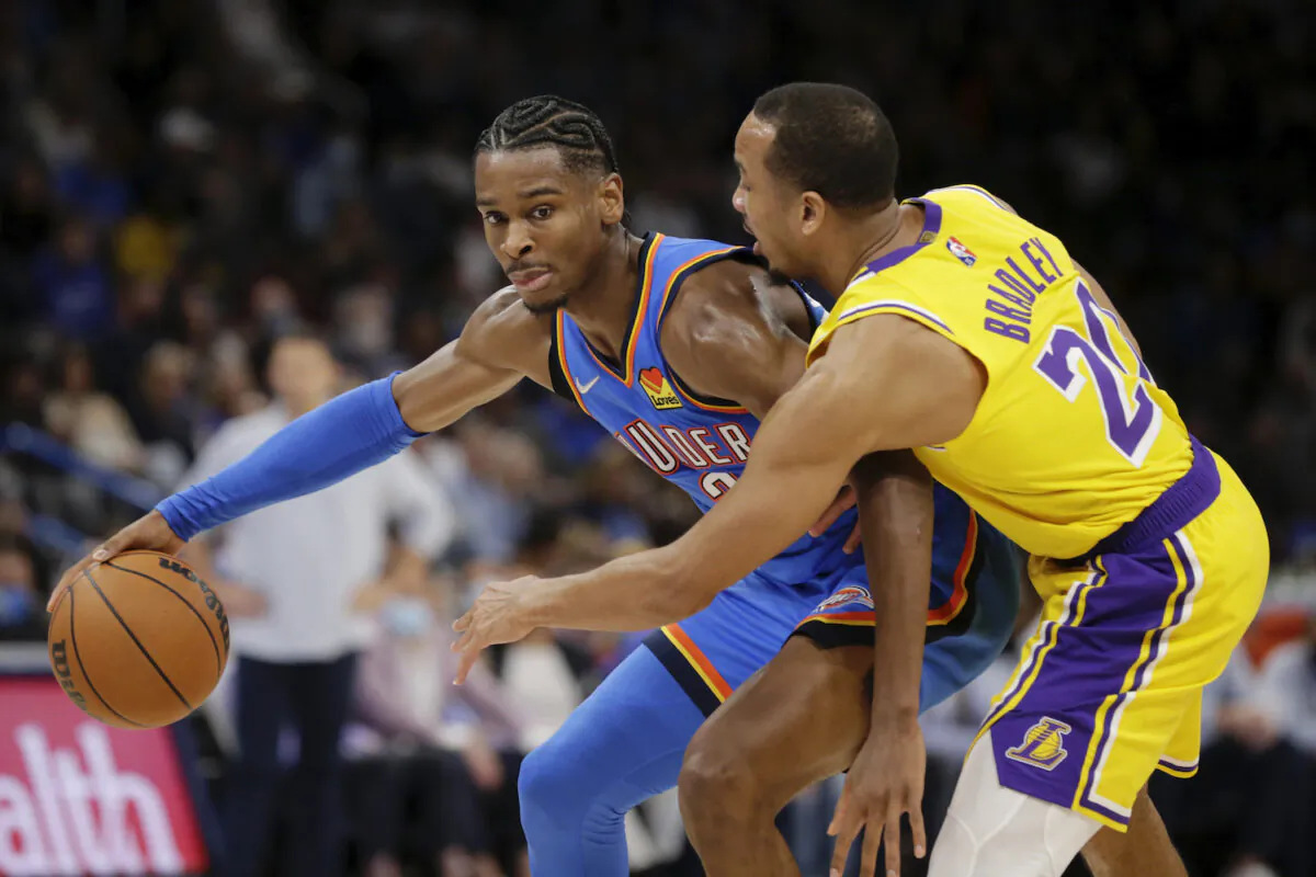 Oklahoma City Thunder guard Shai Gilgeous-Alexander (2) goes against Los Angeles Lakers guard Avery Bradley (20) during the second half of an NBA basketball game in Oklahoma City on Oct. 27, 2021. (AP Photo/Garett Fisbeck)
